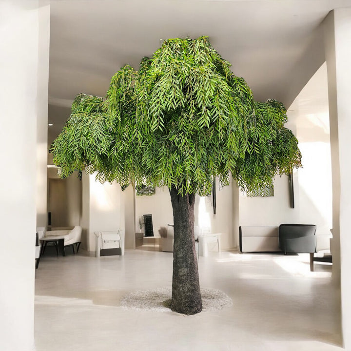 Large artificial willow tree in a modern indoor setting with minimal decor.