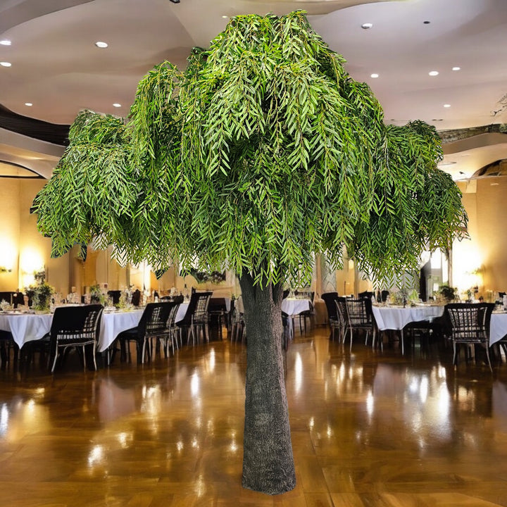 Large artificial willow tree in a banquet hall with tables and chairs.