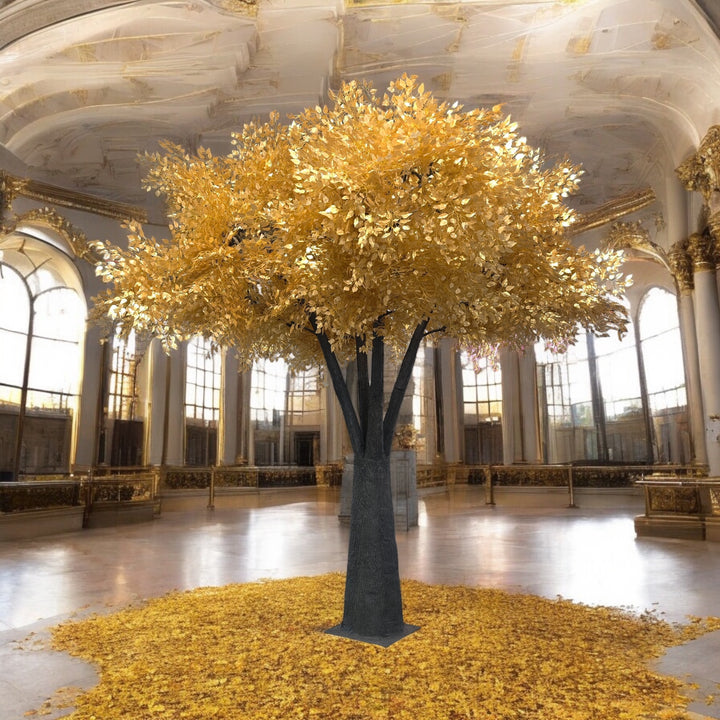 Large decorative ficus tree with gold leaves in a grand room with high ceilings and large windows.