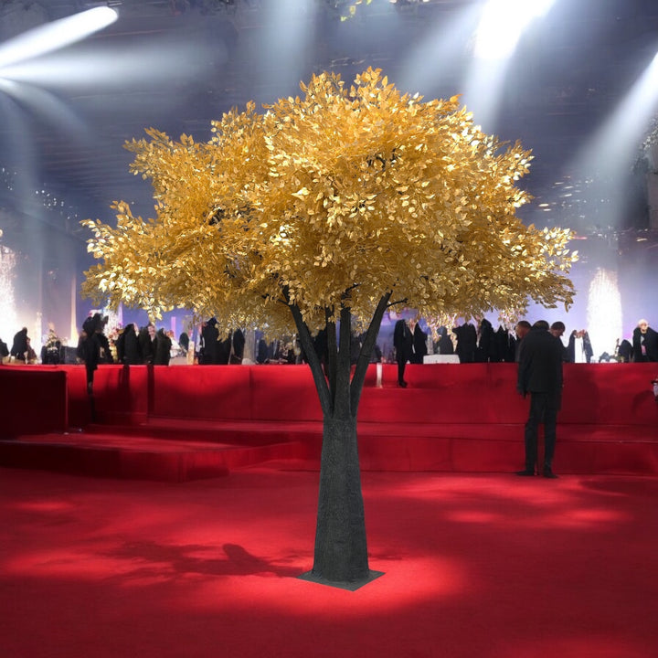 Decorative gold ficus tree on a red carpet with people in the background