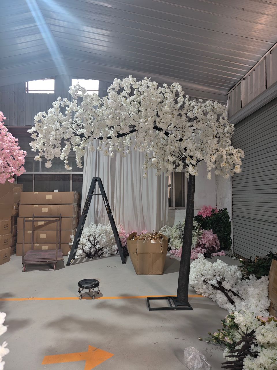 Realistic and elegant white weeping cherry blossom arch tree in a warehouse setting.