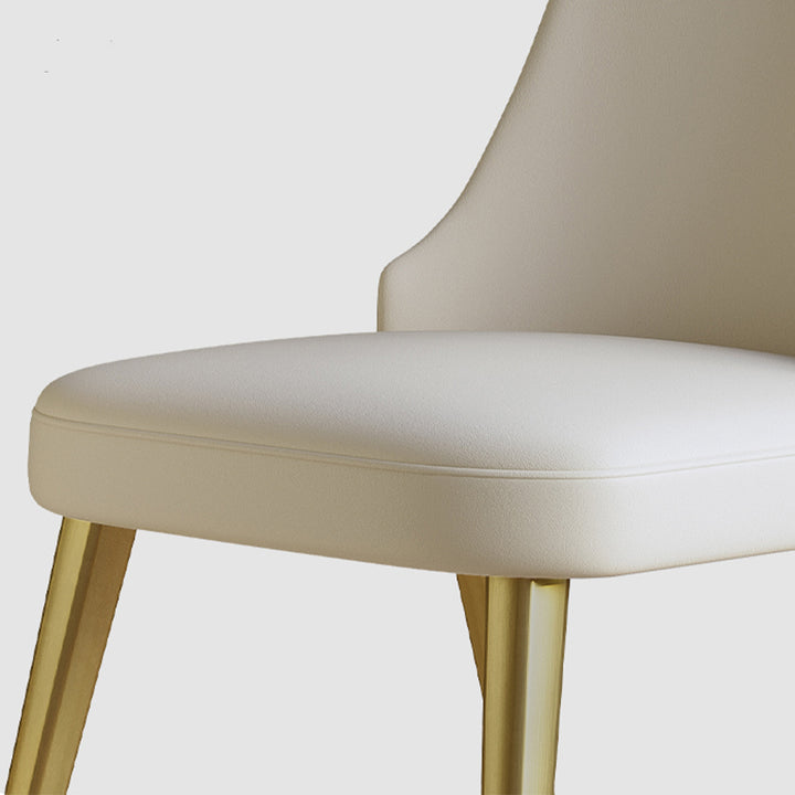 Close-up of a sleek cream dining chair with gold metal legs, showcasing its soft cushion and modern design. Frequently asked questions include 'What is the most comfortable material for dining chair seats?' and 'How durable are gold metal legs on dining chairs?