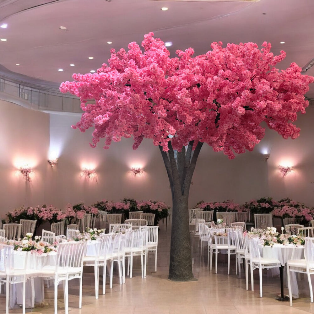 Vibrant artificial dark pink cherry blossom tree with pink blossoms, creating a romantic atmosphere in a wedding venue.