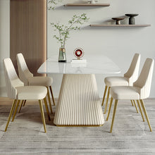 Load image into Gallery viewer, Contemporary dining room setup with a rectangular marble table featuring a fluted base, surrounded by six cream upholstered chairs with gold legs, set against a minimalist backdrop with modern decor elements
