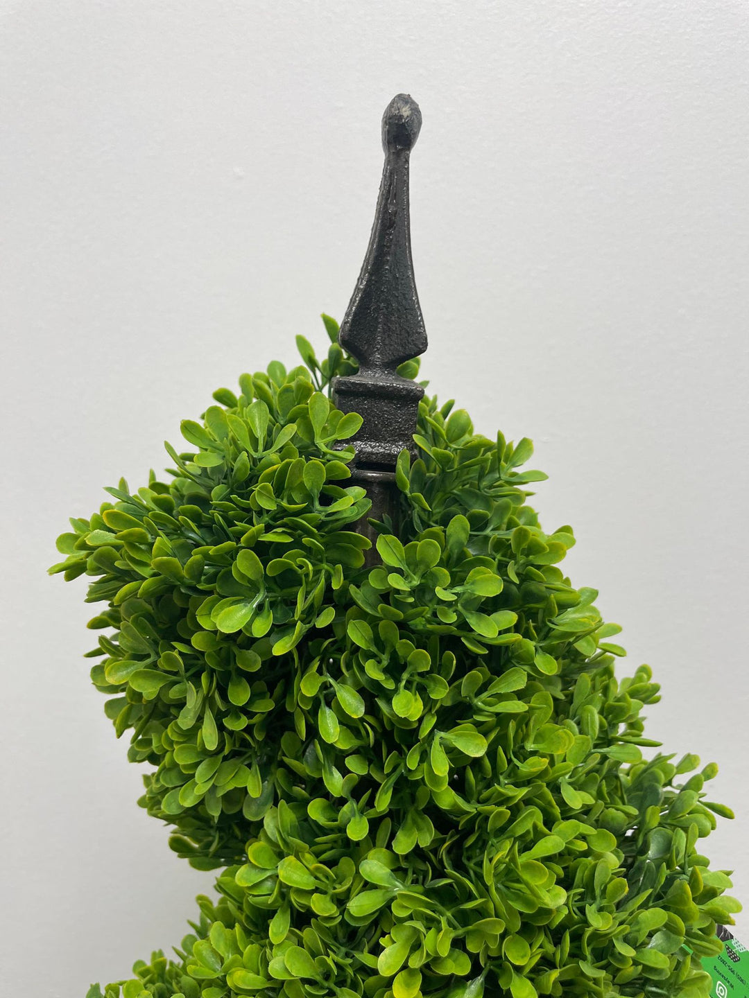 Artificial topiary with dense green foliage and decorative black finial detail, ideal for elegant indoor or outdoor décor.