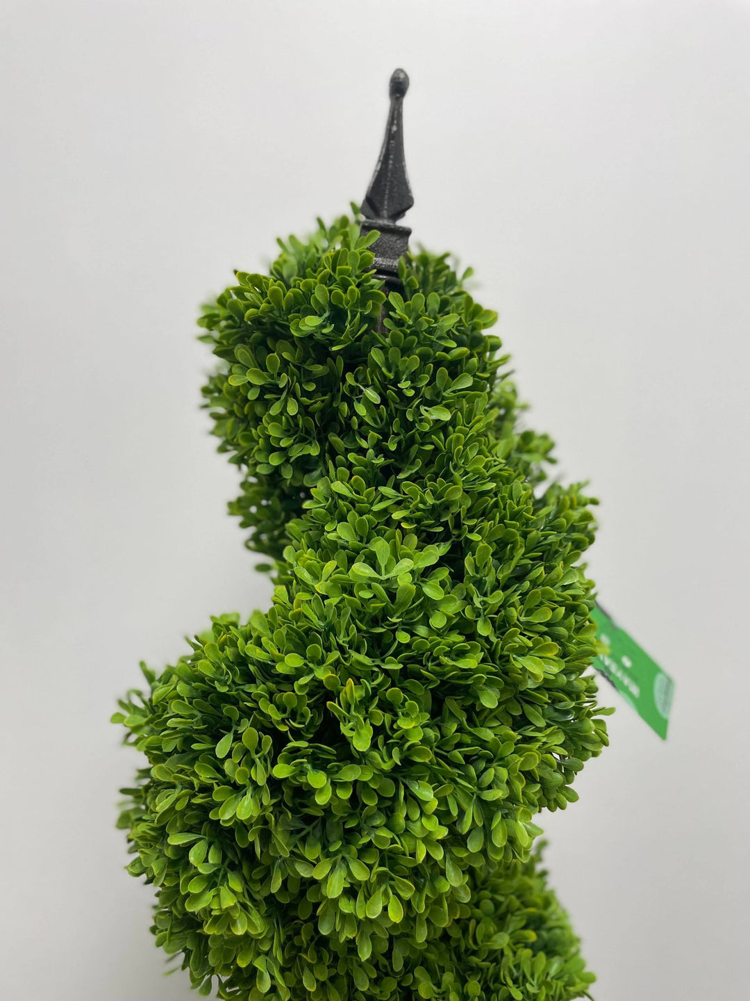 Artificial topiary with dense green foliage and decorative black finial detail, ideal for elegant indoor or outdoor décor.