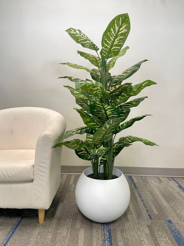 Large artificial plant with lush green leaves in a modern white planter, perfect for enhancing indoor spaces such as offices or living rooms.