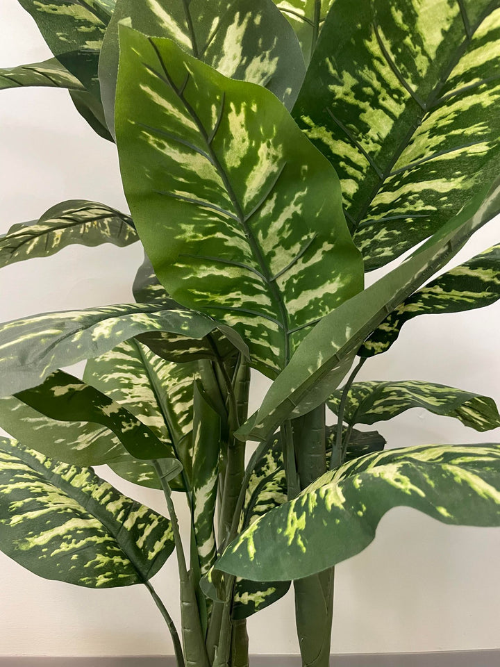 Close-up view of a vibrant artificial plant with variegated green leaves, ideal for adding a natural touch to indoor spaces.