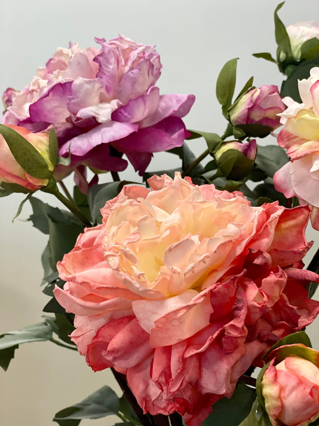 A vibrant bouquet of artificial roses in shades of pink, white, and purple with realistic textures and leaves. Frequently asked question: How do I choose the best artificial flowers for home decor that look real?