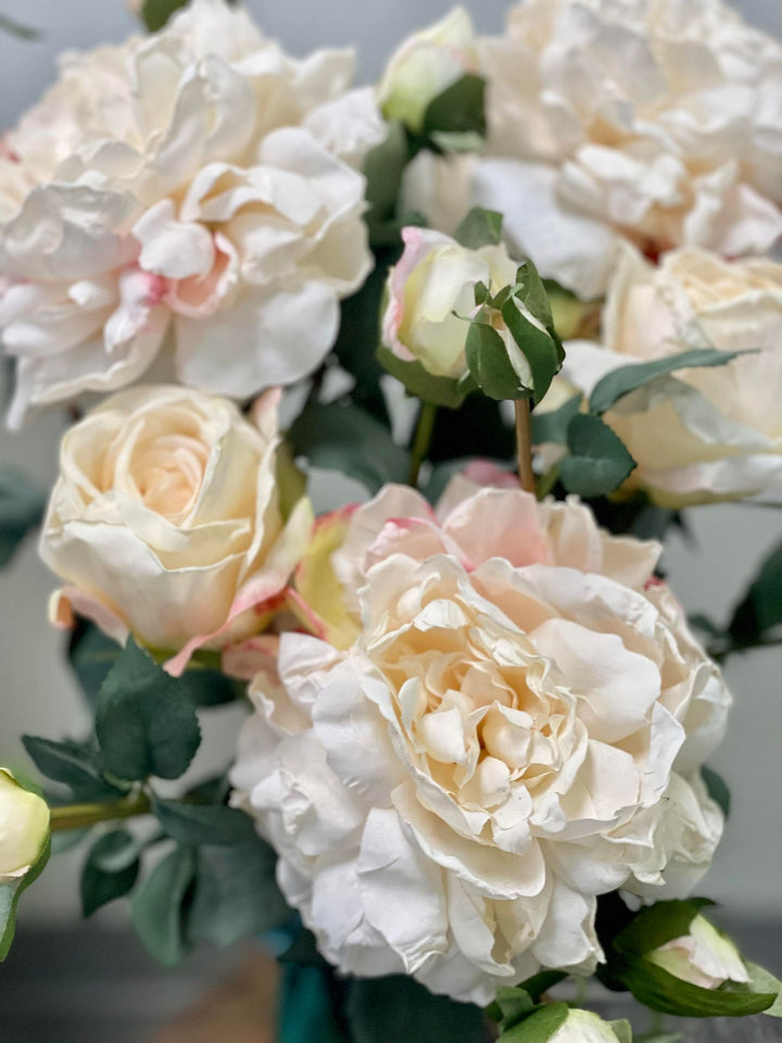Close-up of artificial white peony flowers with green leaves. Common question: How can I arrange artificial peonies to look realistic in a vase?