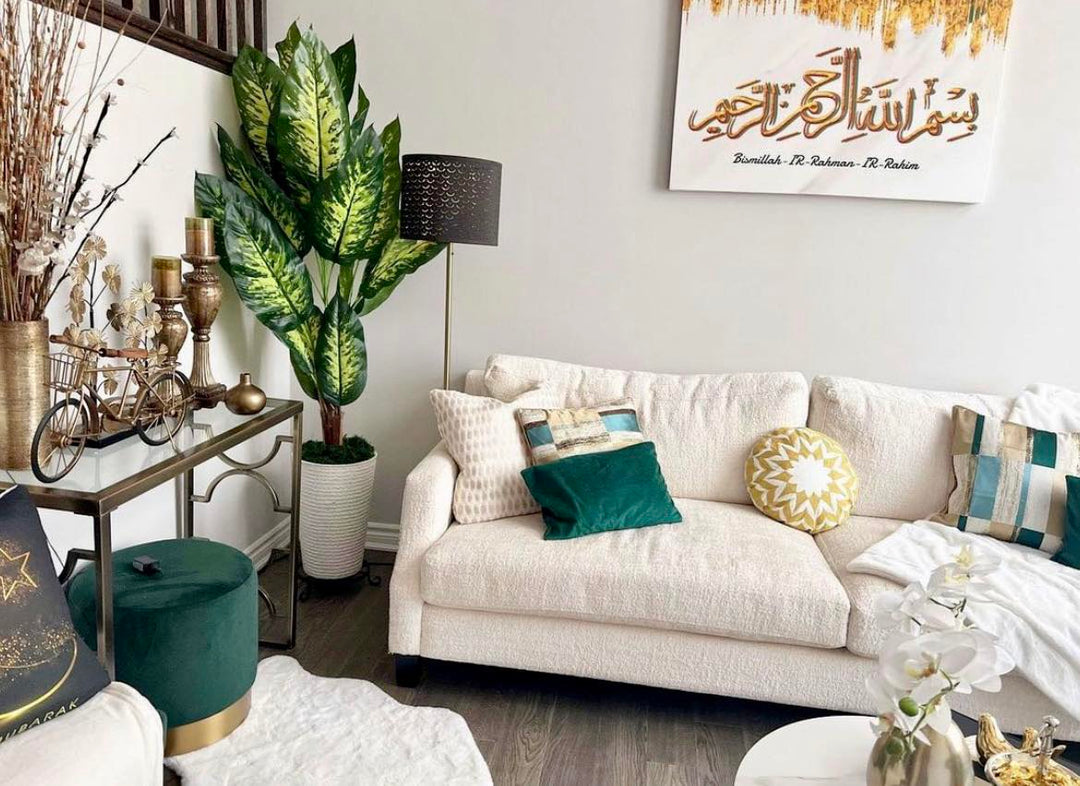 A cozy living room setup featuring a variegated green plant in a textured pot, adding a fresh, vibrant touch to the neutral-toned space. The room is accented with gold decor and a beautiful wall art piece, creating a harmonious and inviting atmosphere.