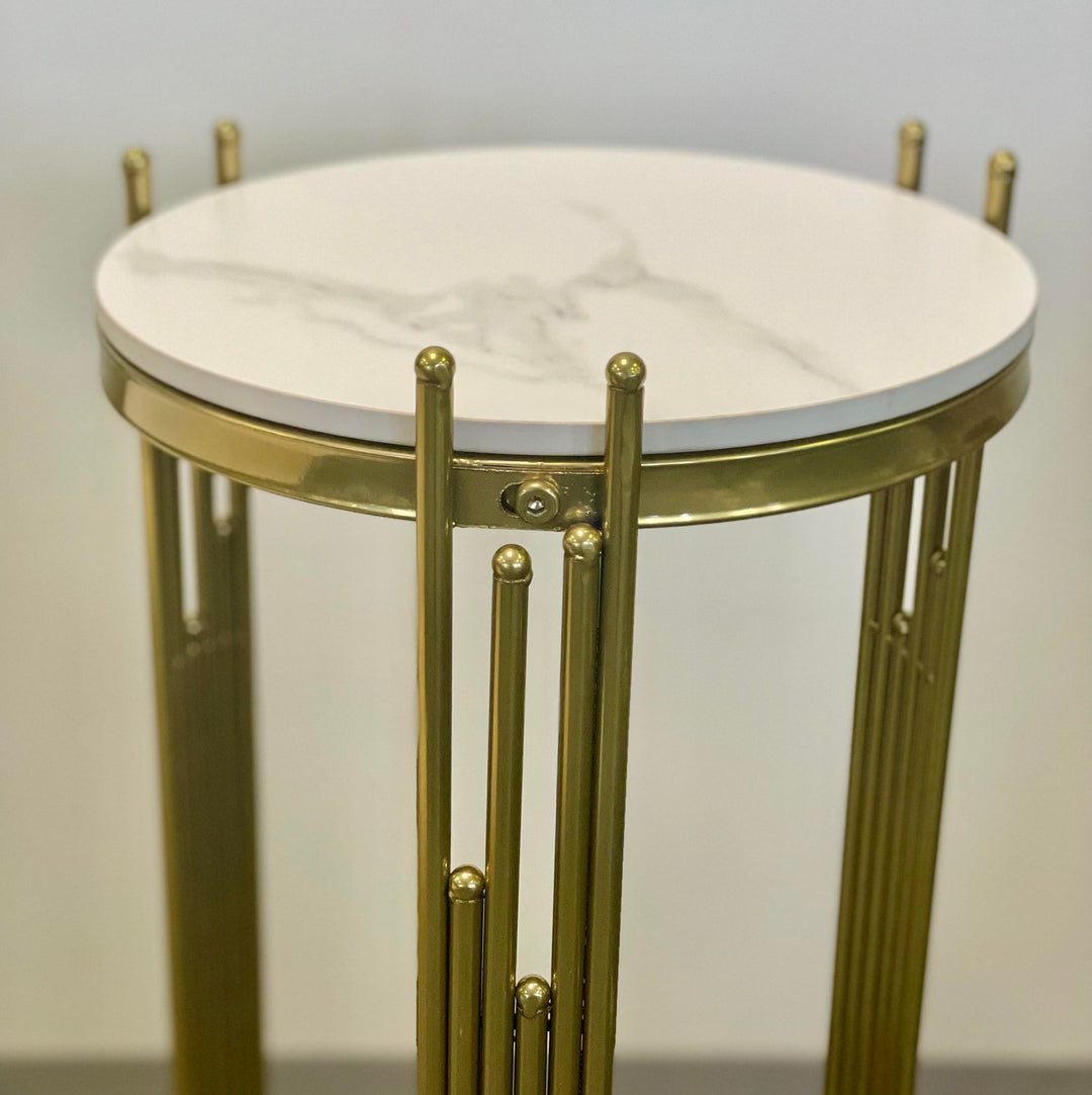 Close-up view of a round marble-top gold metal plant stand, perfect for home decor. Common queries may include: 'Is marble good for plant stands?' 'How do you clean marble and metal plant stands?' and 'What styles of plant stands work best with modern interiors?