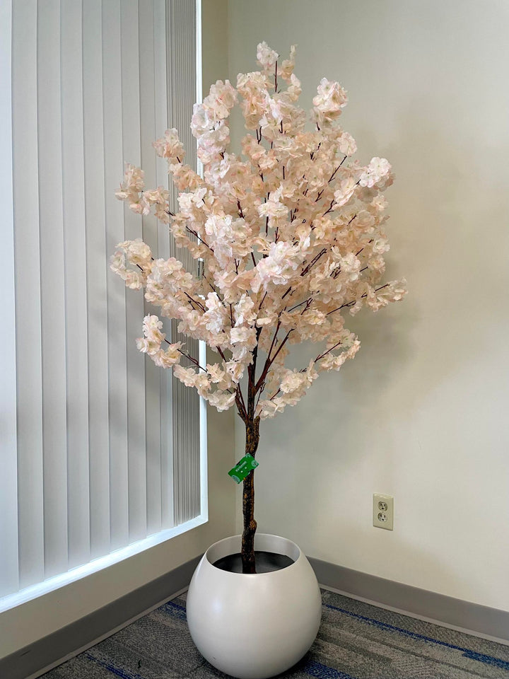 Artificial cherry blossom tree in a minimalist white planter, perfect for brightening up any indoor space with its delicate pink flowers