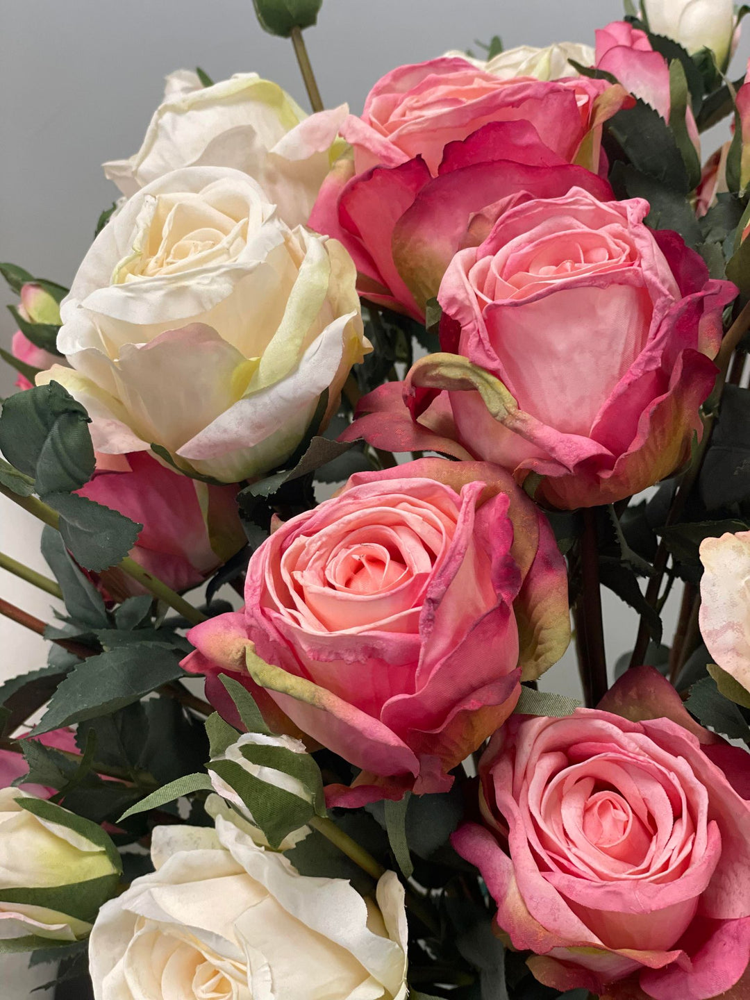 Close-up of artificial pink and white roses with detailed petal textures. Frequently asked question: What are the best tips for maintaining artificial flowers and keeping them looking fresh?