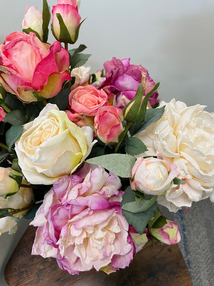 A vibrant bouquet of artificial roses in shades of pink, white, and purple with realistic textures and leaves. Frequently asked question: How do I choose the best artificial flowers for home decor that look real?