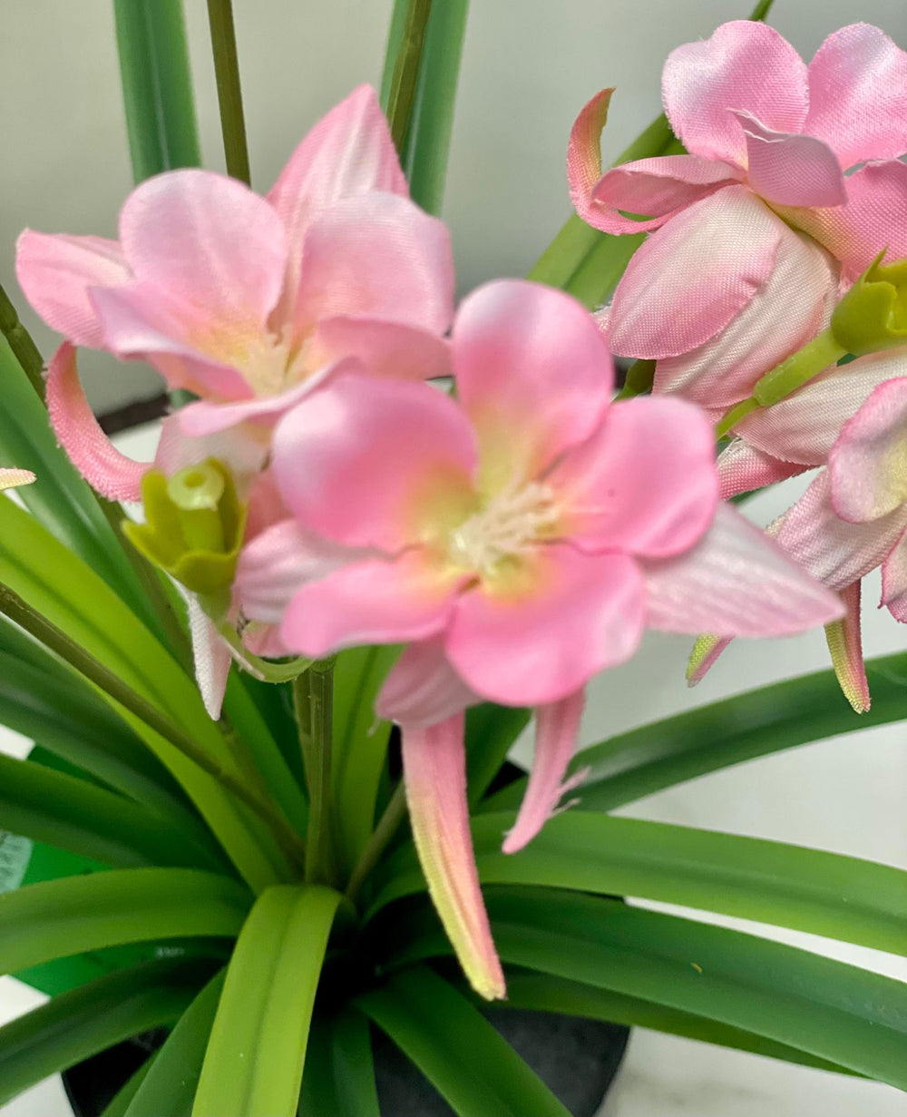 Close-up of pink artificial flowers with soft, delicate petals and vibrant green leaves.