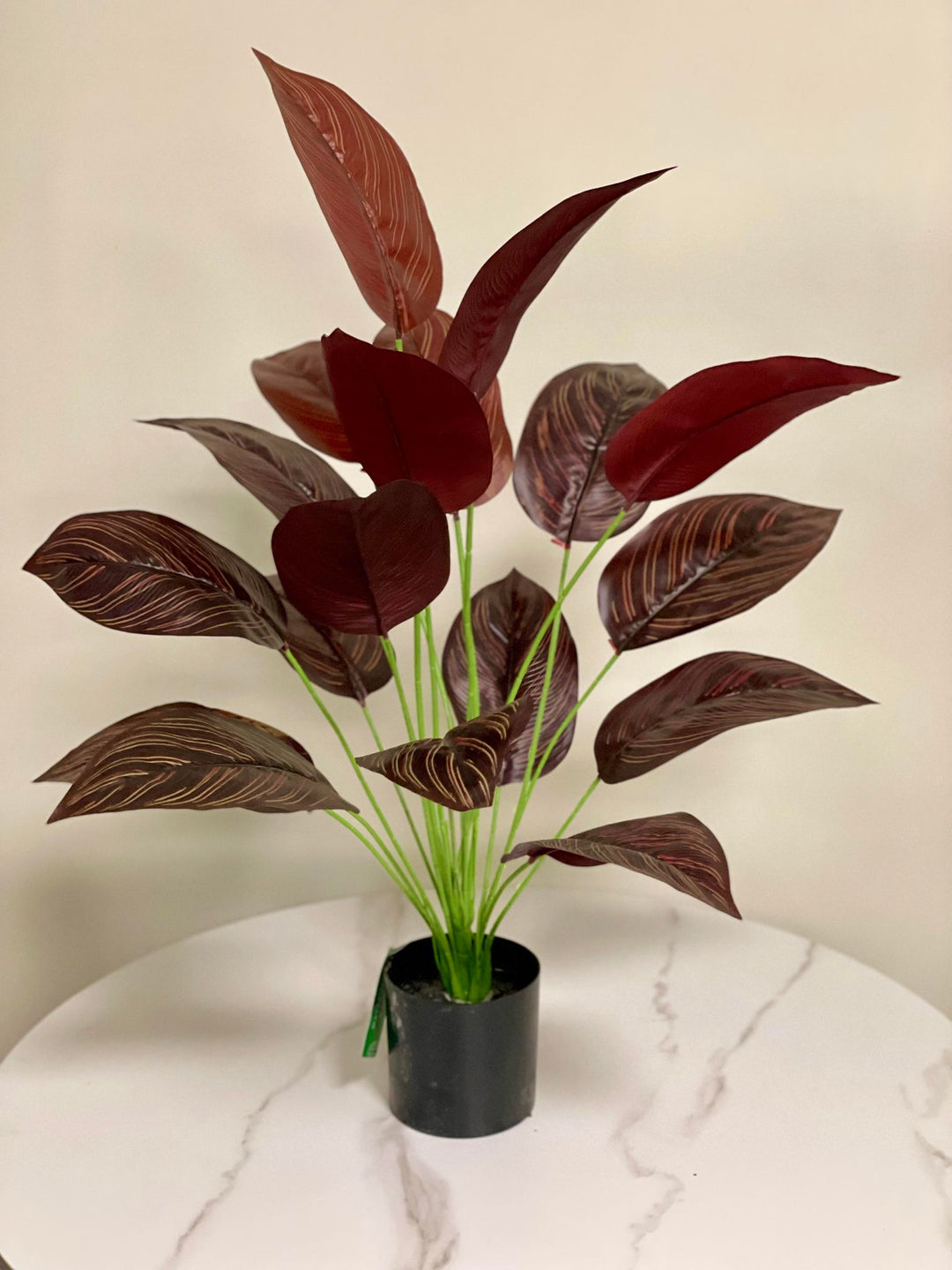 Elegant artificial dark red tropical plant with broad, textured leaves, perfect for adding a touch of sophistication to indoor spaces.