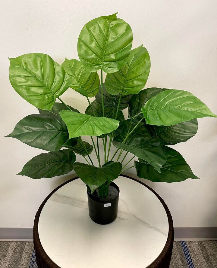 Realistic artificial tropical plant in black pot, featuring large green leaves, ideal for modern home and office decoration.