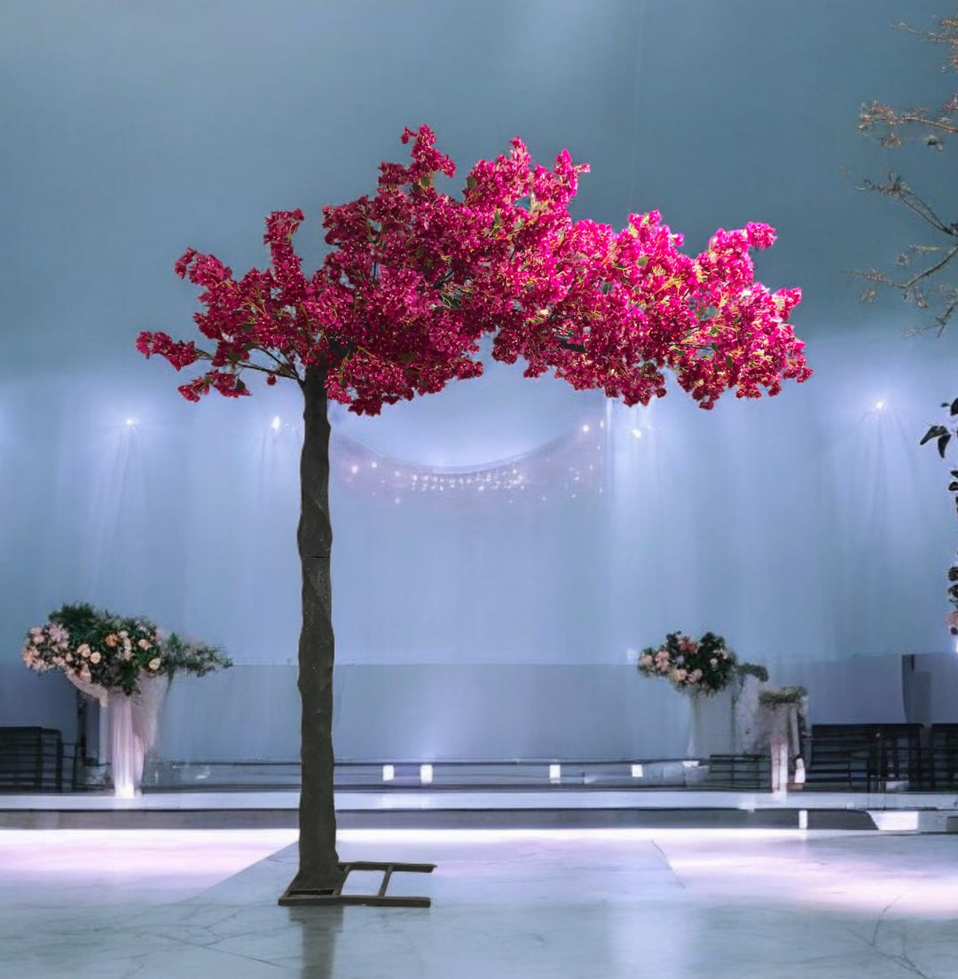 Vibrant pink artificial cherry blossom tree placed in a modern wedding venue with soft blue lighting and a minimalist stage backdrop. This floral decoration adds a striking pop of color and elegance. Can these cherry blossom trees be used for outdoor events?