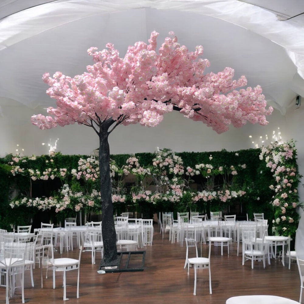 Elegant artificial cherry blossom tree with pink flowers, perfectly placed amidst a lavishly decorated wedding venue featuring pink floral arrangements and cascading fairy lights. Can this artificial tree be customized to match different event themes?