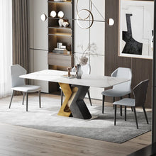 Charger l&#39;image dans la galerie, Contemporary white rectangular dining table with unique black and gold geometric base design, accompanied by modern gray upholstered dining chairs in a stylish interior setting.
