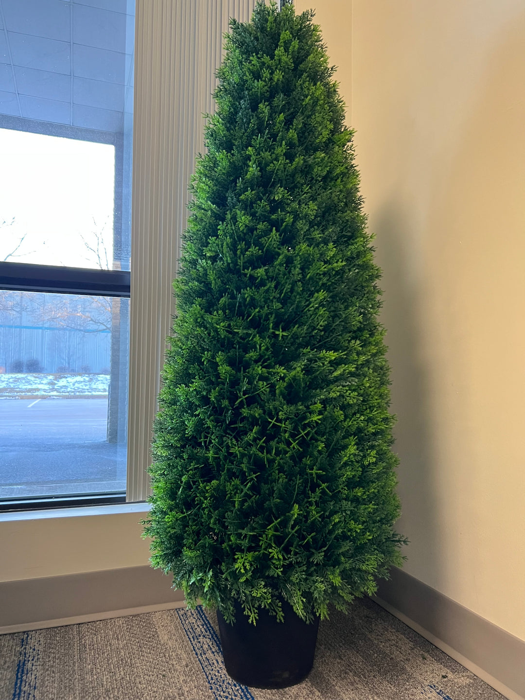 Artificial topiary tree in a black pot, perfect for adding a touch of greenery to indoor spaces such as offices or homes.