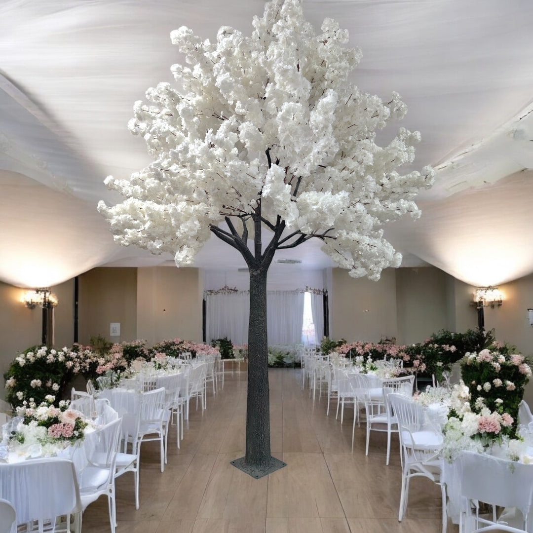Elegant white artificial cherry blossom tree standing tall in a beautifully decorated wedding venue with white and pastel floral arrangements. Perfect for enhancing wedding or event decor with a touch of sophistication and nature. How durable are artificial trees for repeated use?