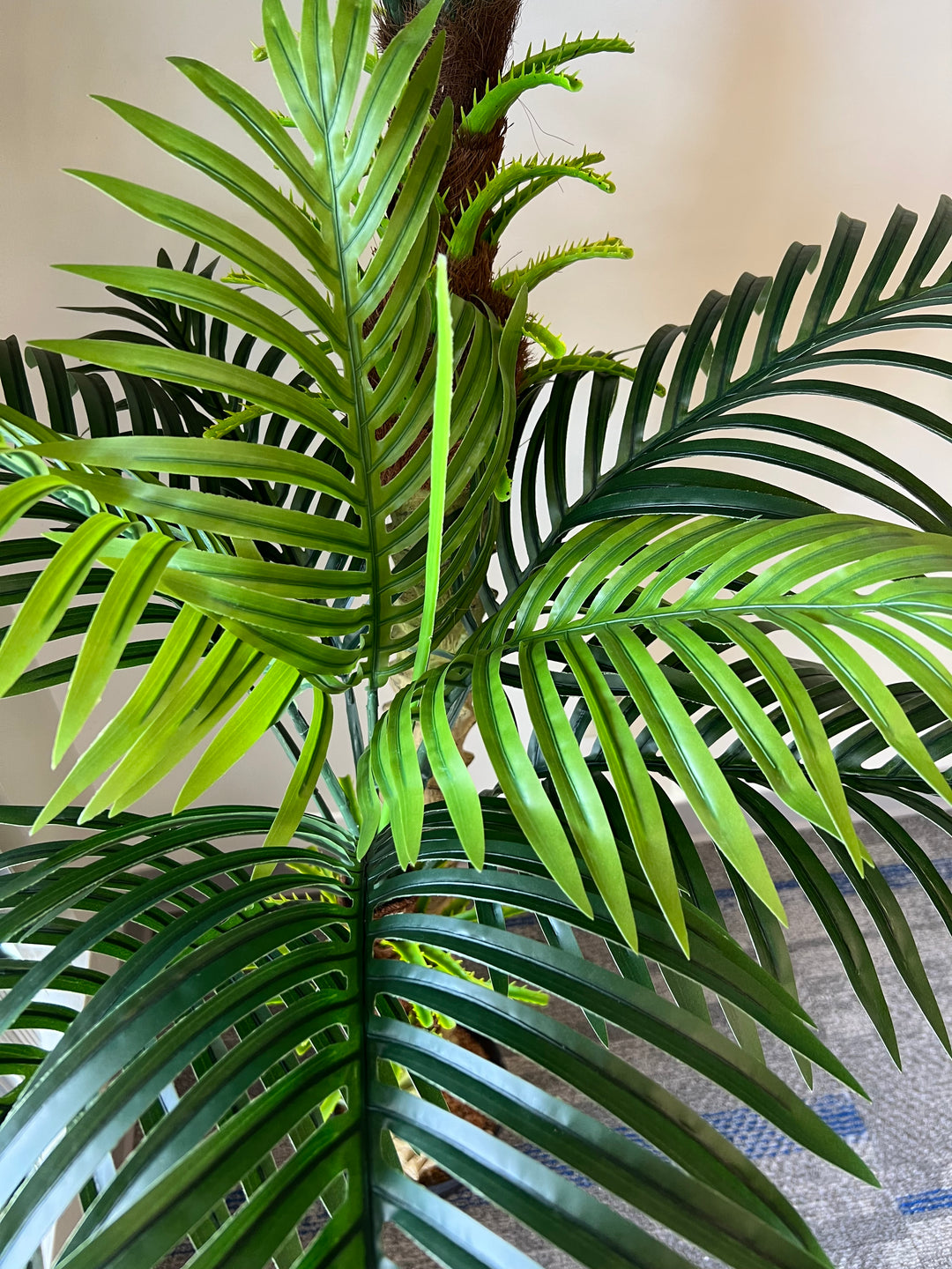 
Close-up of artificial palm fronds, showcasing vibrant green leaves and realistic detailing, ideal for indoor decoration.