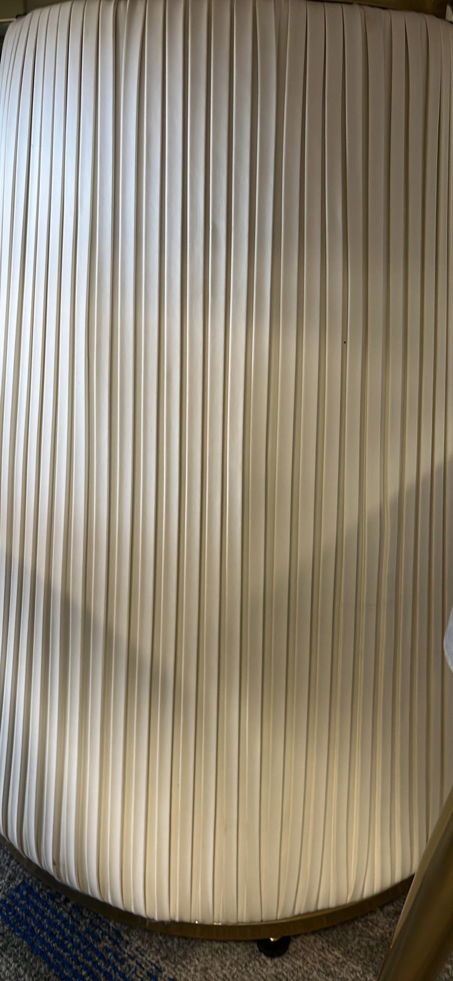 Close-up of a fluted base on a modern dining table, showcasing vertical grooves in a smooth cream finish, highlighting the elegant and contemporary design.
