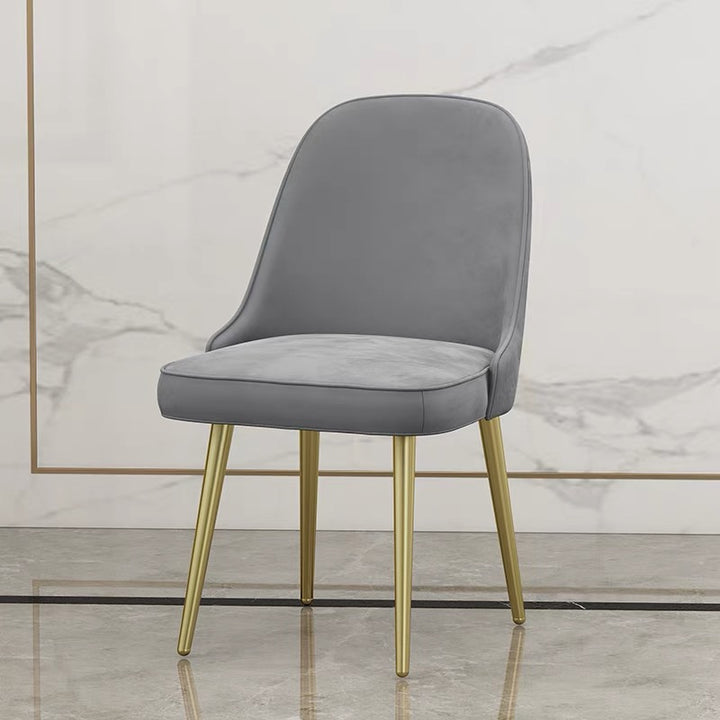 A contemporary gray velvet dining chair with gold legs, designed to add a touch of elegance to any modern dining room. Popular questions include ‘Are velvet dining chairs durable?’ and ‘What type of chairs are best for modern minimalistic interiors?