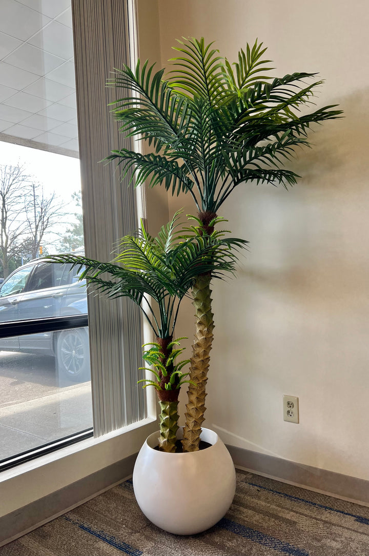 Artificial palm tree in a stylish white planter pot, ideal for enhancing modern living rooms or office environments.