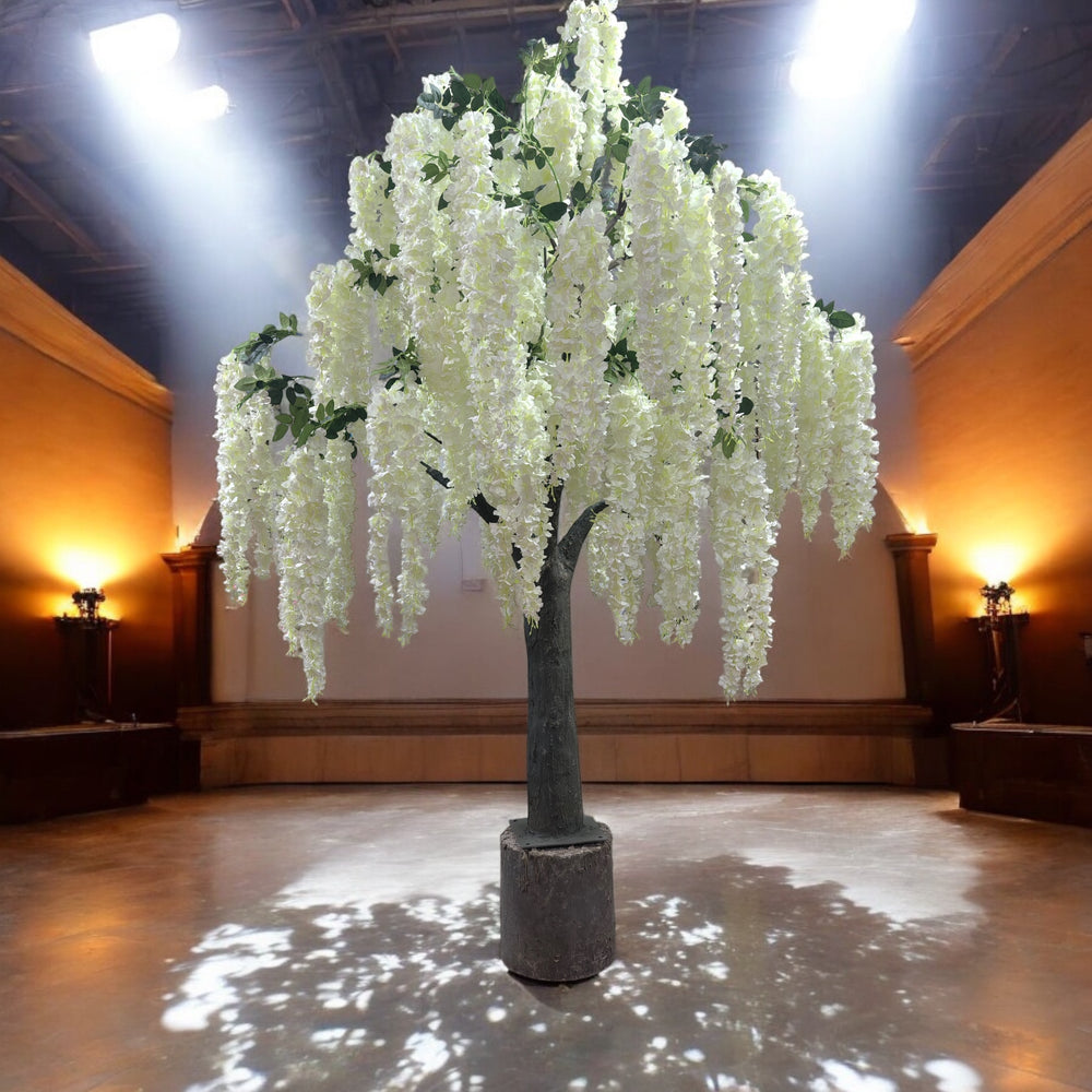 Stunning artificial white wisteria tree with cascading floral displays, illuminated under elegant lighting in a grand event venue. 