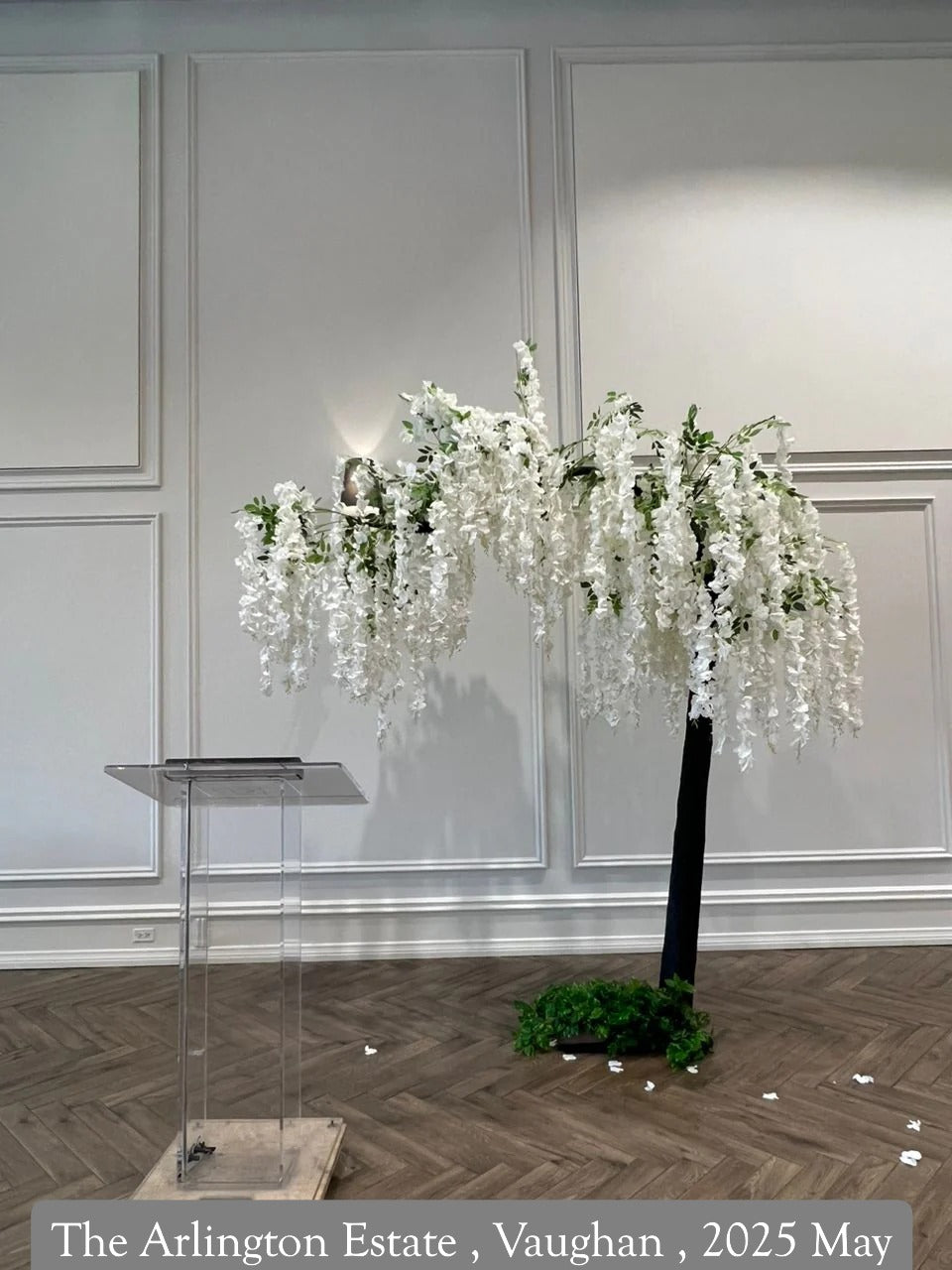 Decorative floral arrangement in a room with white walls and wooden flooring.