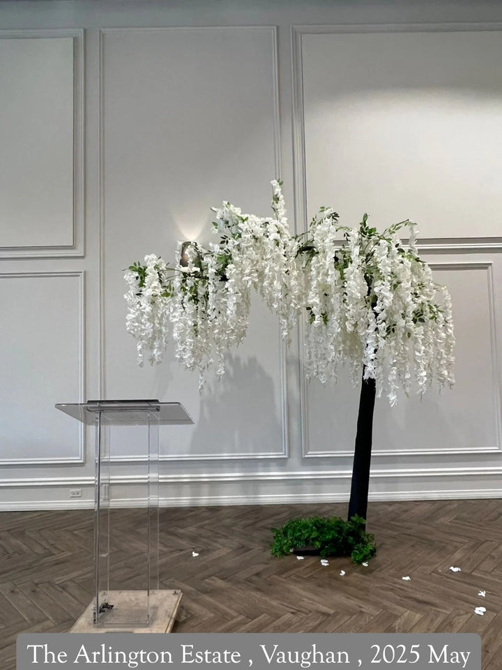 Decorative floral arrangement in a room with white walls and wooden flooring.