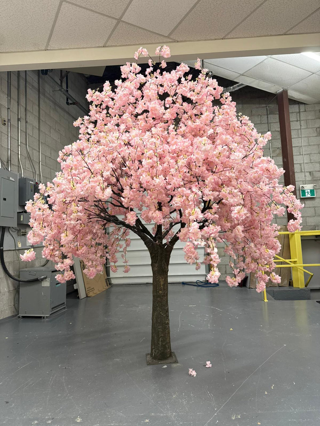 Artificial cherry blossom tree with pink flowers in an indoor setting