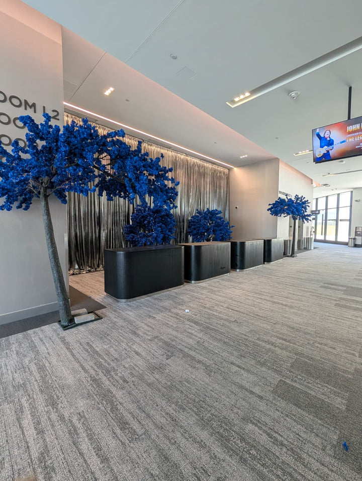 Modern interior with royal blue cherry blossoms decorative trees and a gray carpet.