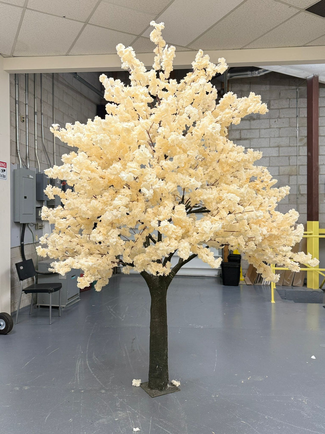 Artificial off white cherry blossom tree in a warehouse setting