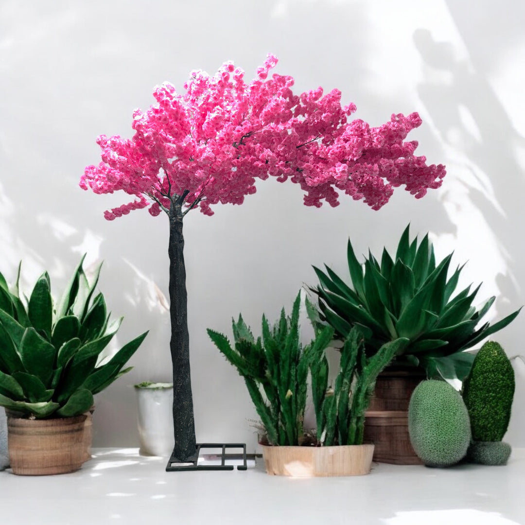 Charming artificial cherry blossom tree with vivid pink blooms displayed alongside lush green potted plants, perfect for enhancing indoor wedding and event decor. Is this artificial tree suitable for outdoor venues?