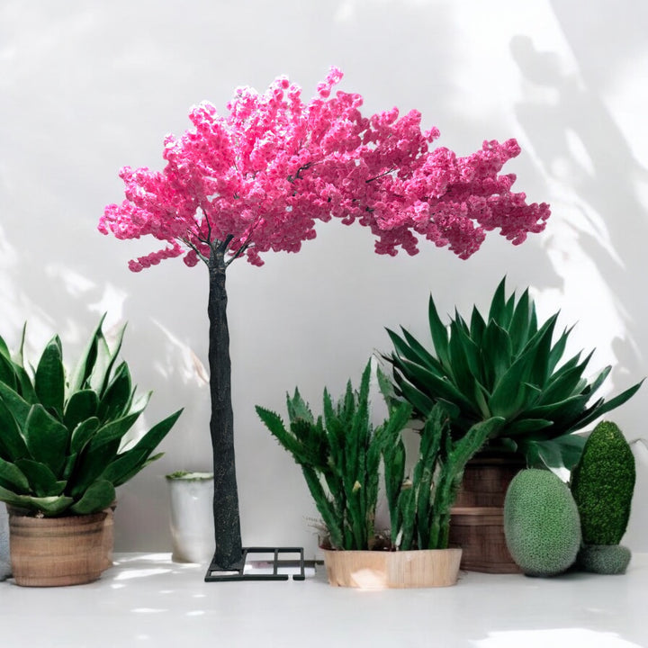 Charming artificial cherry blossom tree with vivid pink blooms displayed alongside lush green potted plants, perfect for enhancing indoor wedding and event decor. Is this artificial tree suitable for outdoor venues?