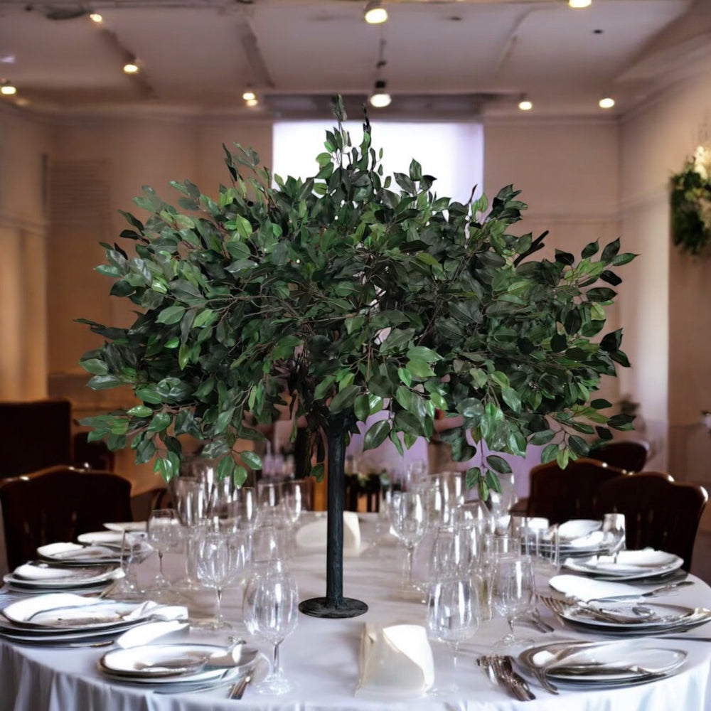 Decorative table setting with green leafy centerpieces in a formal dining room.