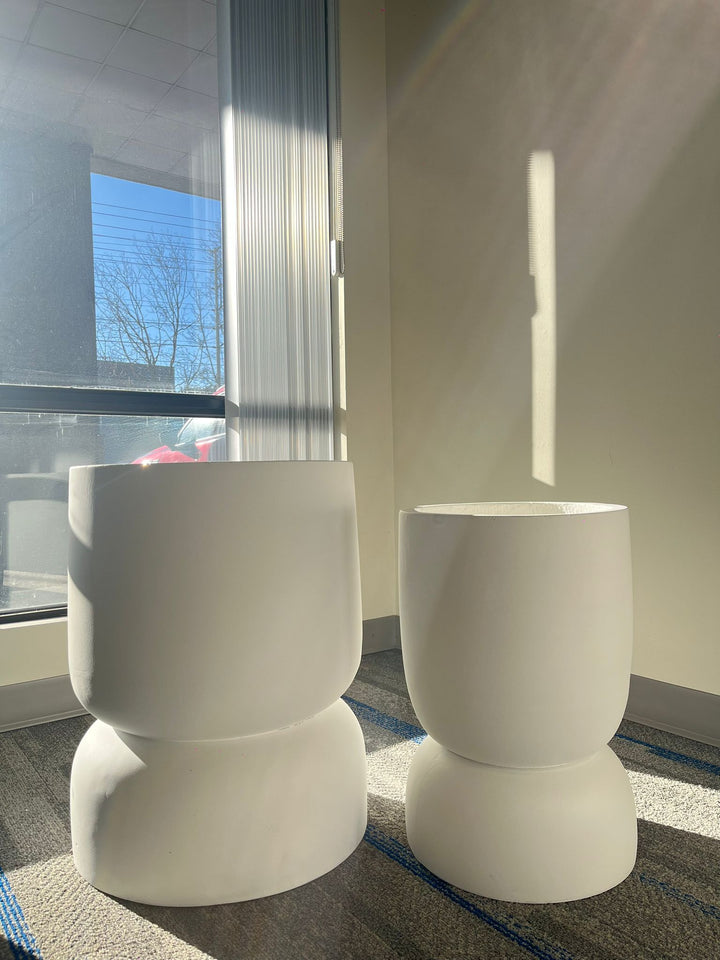 Set of two white stackable planters with a smooth matte finish, displayed empty indoors near a window with natural sunlight. Are these planters suitable for both indoor and outdoor use?