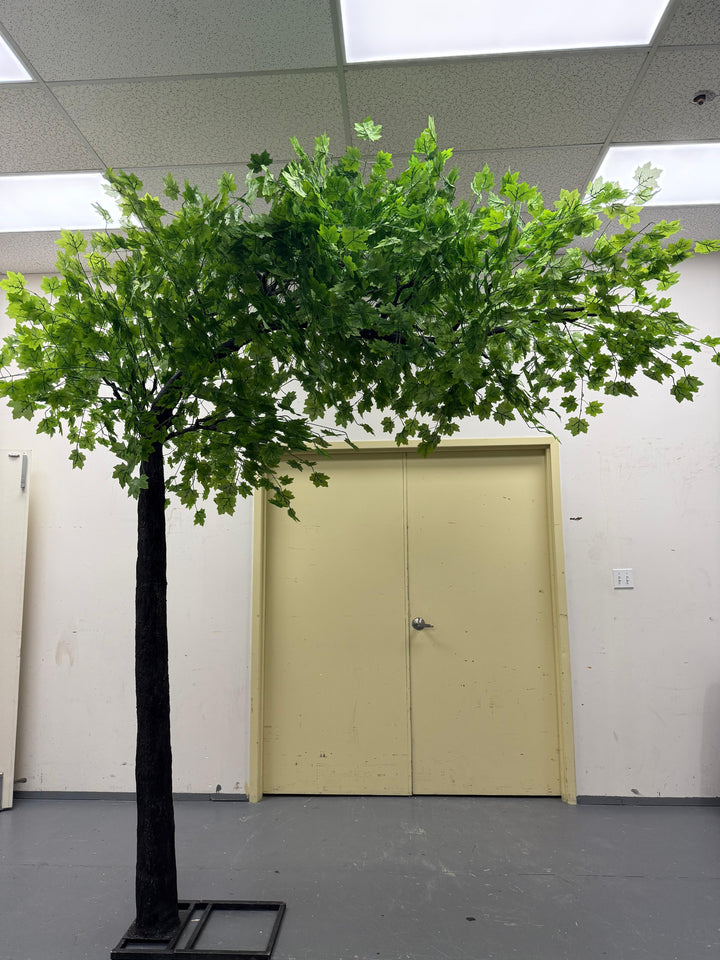 realistic artificial maple tree with oversized leaves and curved structure.