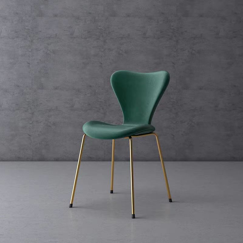 Contemporary green chair with gold legs, set against a minimalistic grey background. Frequently asked questions include 'What are the most comfortable chair designs for dining rooms?' and 'How do you maintain velvet upholstery on modern chairs?