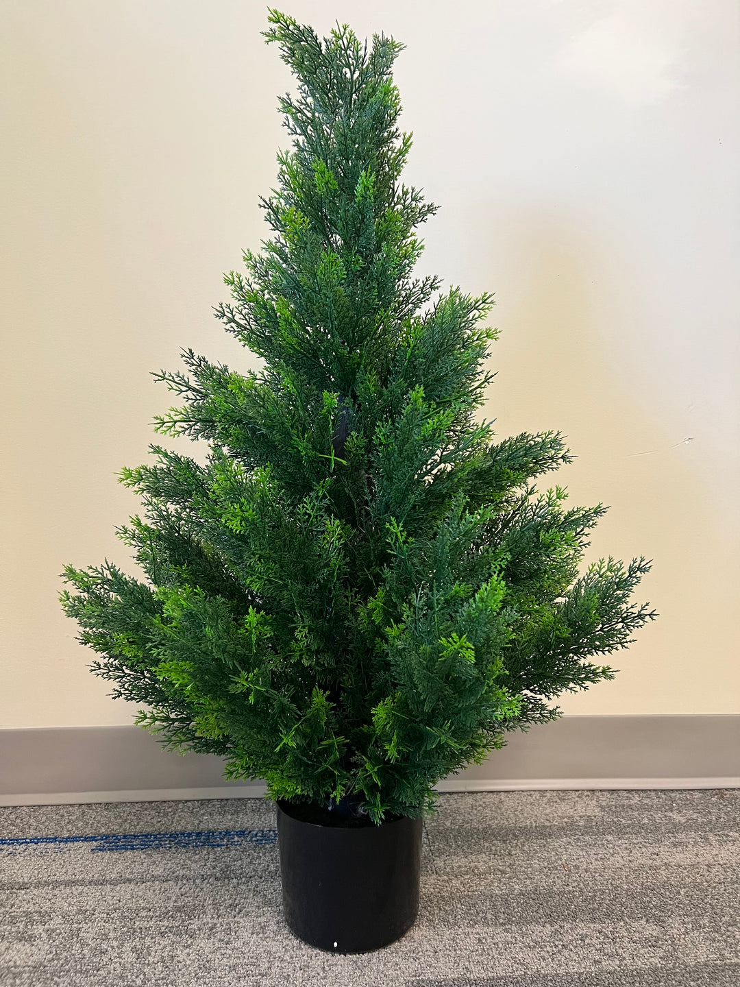 Artificial small evergreen tree in a black pot, featuring dense, lush green foliage, ideal for adding a touch of greenery to indoor spaces.