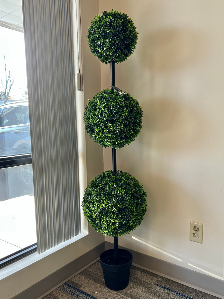 three-tier artificial topiary tree in a black planter next to a window arrangement, perfect for enhancing indoor spaces with a touch of greenery and style
