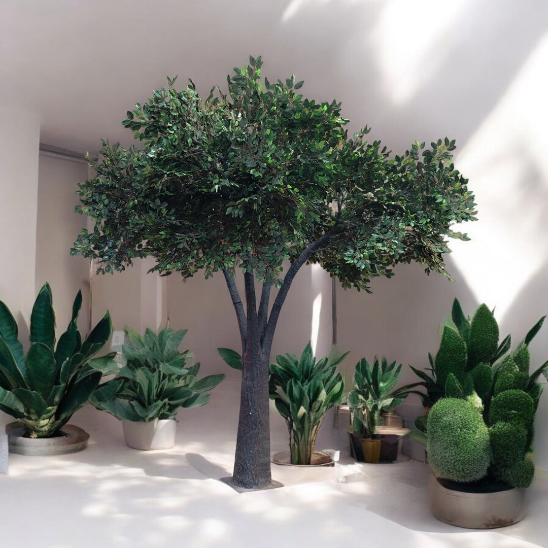 Elegant artificial tree with a realistic trunk and lush green foliage, surrounded by decorative potted plants, ideal for creating a sophisticated ambiance at weddings and events. Are these rental trees customizable to match different event themes?