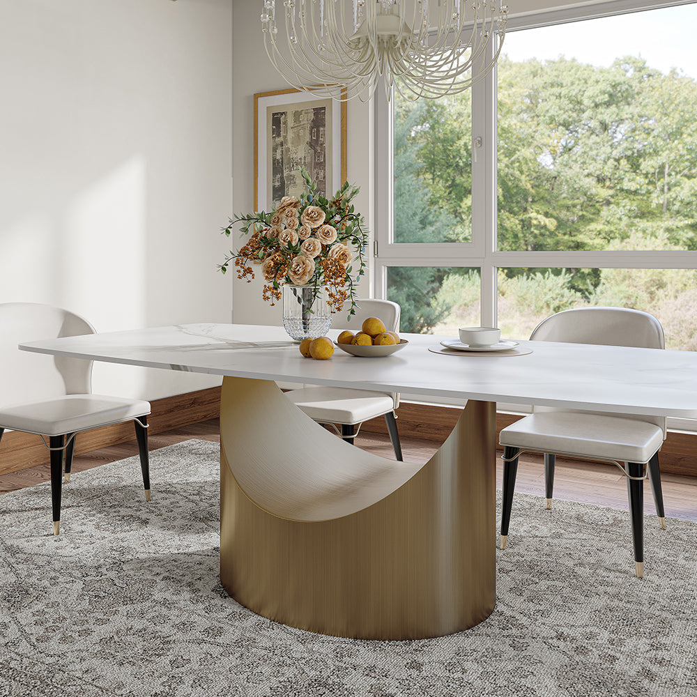 Modern dining table with a white marble surface and a unique gold crescent-shaped base, complemented by white upholstered chairs
