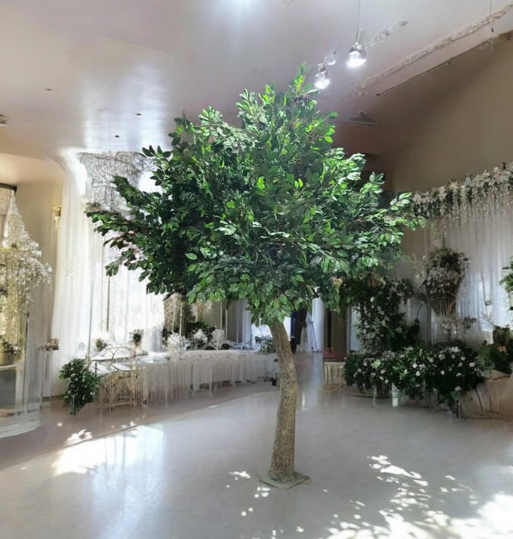 A 10ft artificial Ficus tree with dense green foliage, ideal for wedding decor, providing a romantic, natural touch, displayed indoors among other floral decorations.