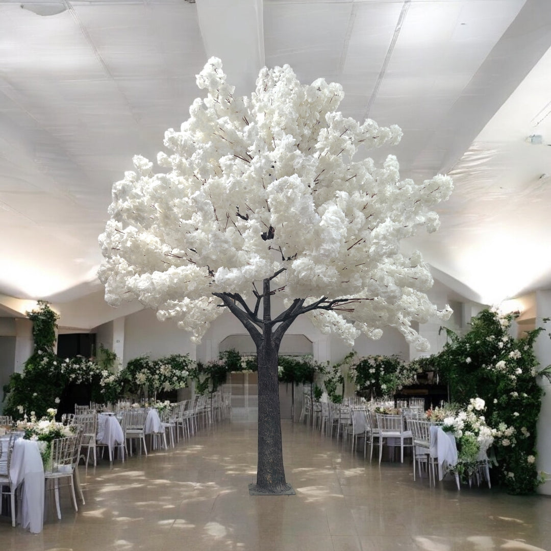 A majestic white artificial blossom tree in an elegant banquet hall adorned with lush green and white floral arrangements. Ideal centerpiece for wedding or formal event decor. Are these artificial trees easy to assemble and disassemble?