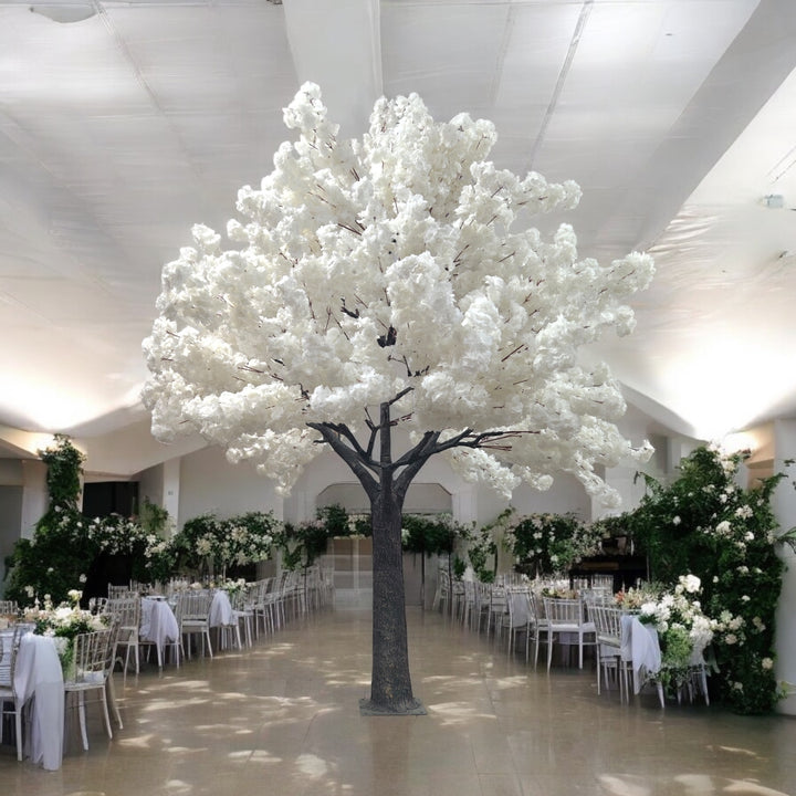 A majestic white artificial blossom tree in an elegant banquet hall adorned with lush green and white floral arrangements. Ideal centerpiece for wedding or formal event decor. Are these artificial trees easy to assemble and disassemble?